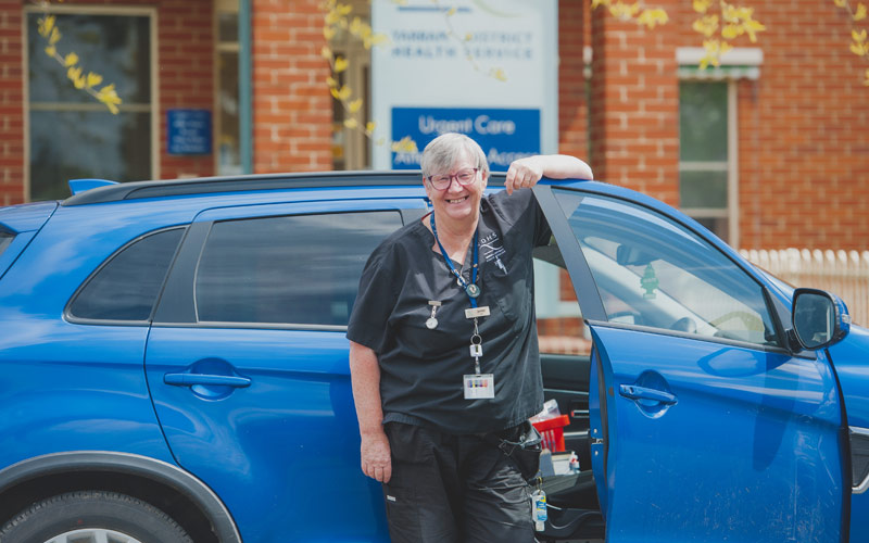 Photo of travelling nurse infront of her car