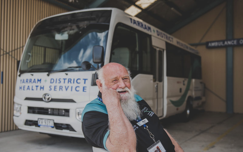 Photo of male volunteer at YDHS with long silver beard infront of mini-bus