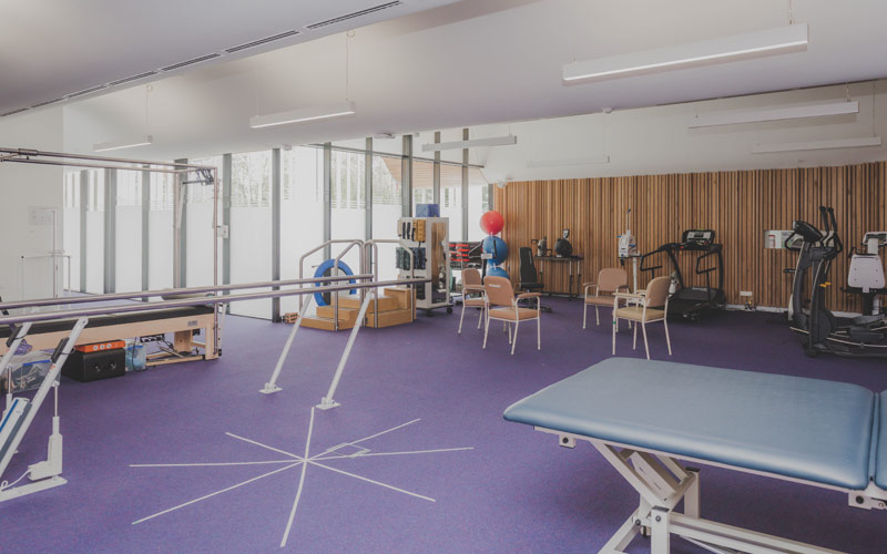 Photo of physiotherapy room with various equipment, purple floor.