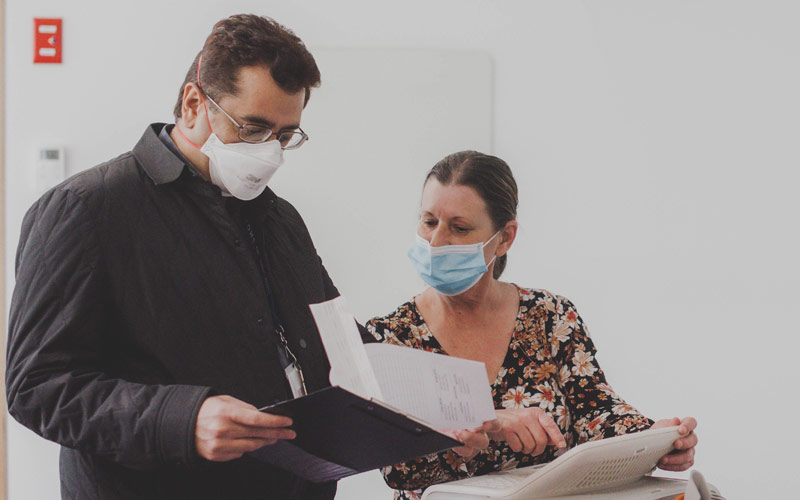 Photo of a doctor and nurse consulting over documents