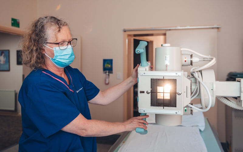 Photo of a female radiologist as she prepares an x-ray machine.